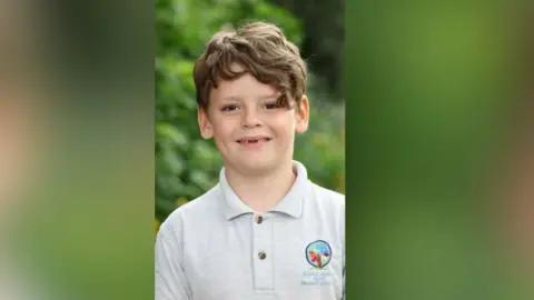 Family handout A boy in a grey polo shirt smiling at the camera