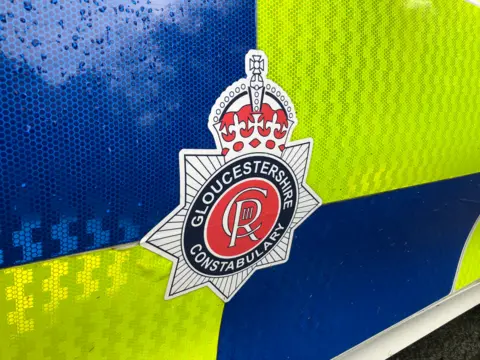 BBC A close up of the side of a police car bearing Gloucestershire Constabulary's crest. 