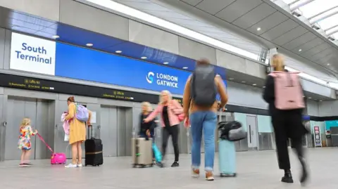 GWR Passengers arriving at the South Terminal at Gatwick Airport with suitcases.