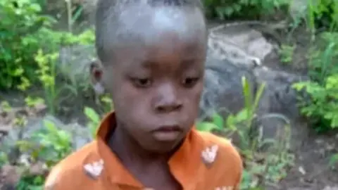 The young boy wearing an orange shirt after being found 