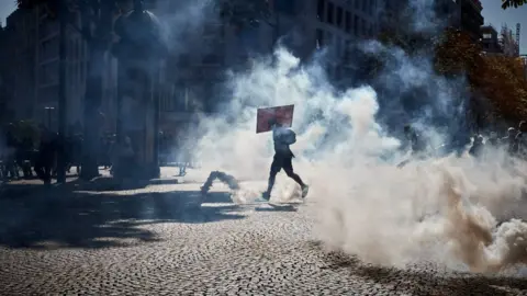 Getty Images Activists run through clouds of tear gas