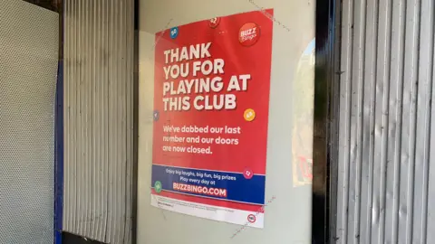 A sign saying "thank you for playing at this club" announcing the closure of a bingo hall. It is in white writing on a red background.