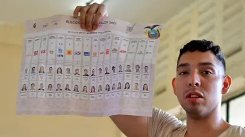 Getty Images An Ecuadorian man holds up a ballot paper during the presidential election