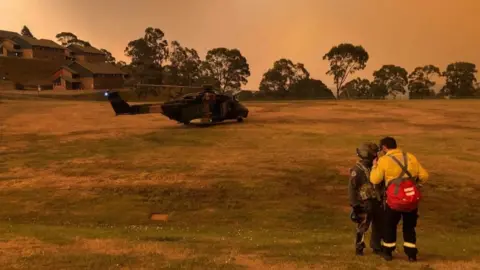 AUSTRALIAN DEPARTMENT OF DEFENCE A helicopter on the field of a residential area in Victoria