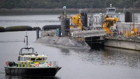 PA Media A submarine sitting in the water at Faslane.