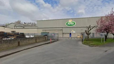 The outside of the Arla factory in Settle. The company's logo can be seen on the side of a building.