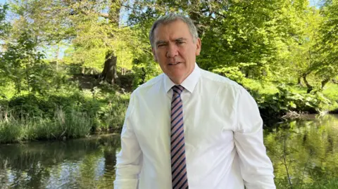 NFU President Aled Jones standing next to a canal in tree shade