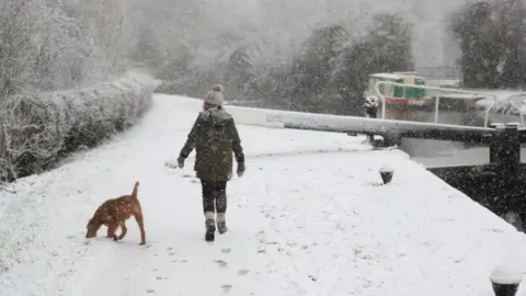 Mike Egerton/PA Wire A dog walker braves the snow in Woolsthorpe, Leicestershire