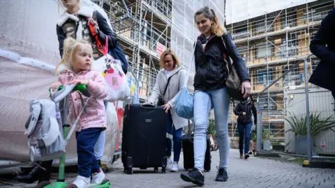 Family leaving an apartment block in Essex following an investigation into fire and safety issues