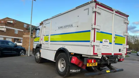 Stuart Woodward/BBC A white bomb disposal van with the reflective yellow and blue strip 