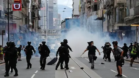 Reuters Riot police fire tear gas into the crowds to disperse anti-national security law protesters during a march at the anniversary of Hong Kong's handover to China from the UK in Hong Kong on 1 July 2020