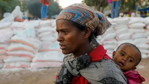 Reuters Woman queues for food at a temporary shelter in Tigray (file pic - March 2021)