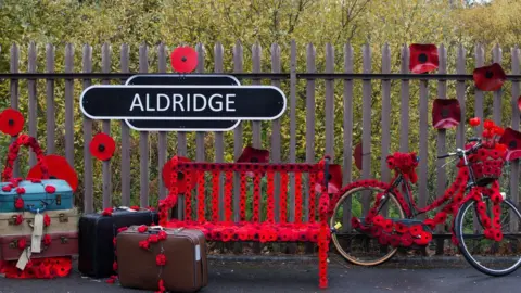 PA A sign in Station Road, Aldridge in Walsall which has transformed itself into Poppy Road as almost 100 houses have been decorated with 24,000 red poppies and silhouette statues of soldiers to honour local people