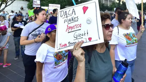 AFP Young immigrants and supporters walk holding signs during a rally in support of Daca in Los Angeles, on September 1, 2017