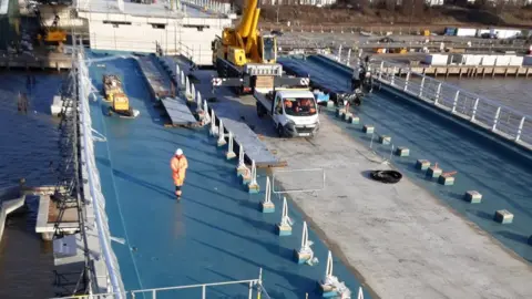 Suffolk County Council Work continuing on the bridge, with part of it covered in blue tarps.