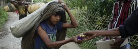 EPA Rohingya refugees receive bread and bananas from local people as they arrive in Tuangiri, Teknaf, Bangladesh (12 September 2017)