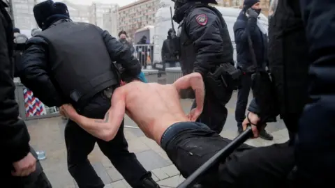 Reuters Law enforcement officers detain and drag topless man during a rally in Moscow