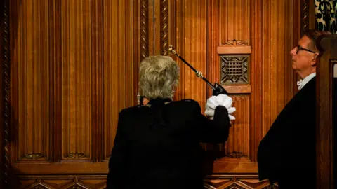 Getty Images Sarah Clarke, Black Rod, bangs on the doors to the house of commons at the beginning of the State Opening ceremony of Parliament at the Palace of Westminster on May 10, 2022