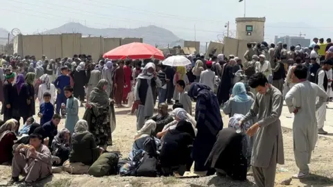 Reuters People wait outside Hamid Karzai International Airport in Kabul, Afghanistan on 17 August 2021