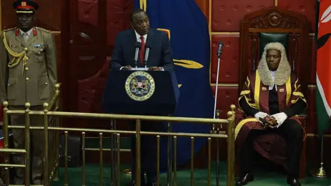 Getty Images President Uhuru Kenyatta (C) flanked by speaker of the National Assembly Justin Muturi (R) addresses the parliament on March 26, 2015 in Nairobi