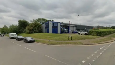 Google A blue and grey warehouse building on an industrial estate