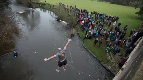 PA A man takes part in the Mappleton Bridge Jump, an annual unofficial tradition where those willing jump from Okeover bridge on New Years Day into the River Dove in Mapleton, Derbyshire.