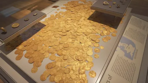 Alamy The Fishpool hoard, the coins with jewellery on separate boards, within a cabinet at the British Museum