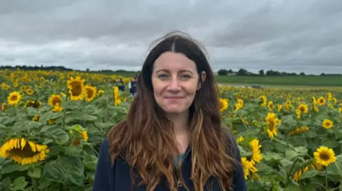 BBC Ashley Evers-Swindell standing in a sunflower field