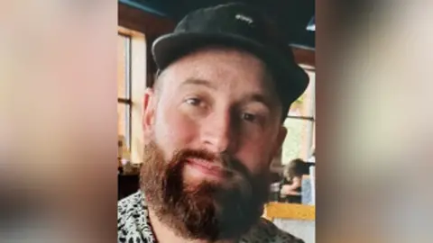 South Yorkshire Police Portrait photo of bearded man wearing black cap