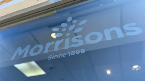BBC Morrisons logo in a shop window