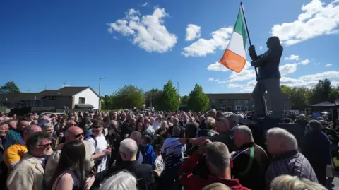 Brian Lawless/PA A crowd at the unveiling of the Bobby Sands statue in west Belfast. The statue holds an Irish tricolour.