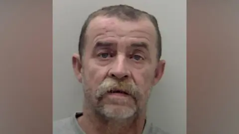 Zvonko Tomisa, who has short hair and a bushy moustache, in a police mugshot.