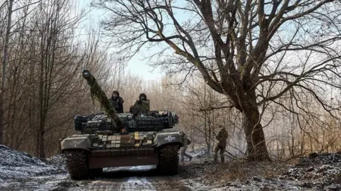 Sipil EPA dari Brigade Tank terpisah ke -3 dari Pasukan Darat Ukraina mengoperasikan tangki di dekat garis depan