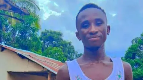 Namina Jenneh A head and shoulders shot of Yayah Jenneh, he is wearing a white vest top.