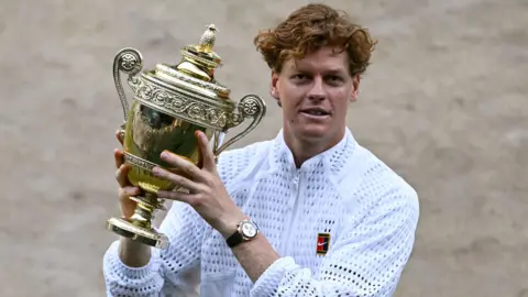 Jannik Sinner holding the Wimbledon men's singles trophy