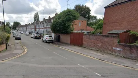 Google A Google street view showing a road of terraced houses with gable windows and cars parked outside. The Dartmouth Road street sign can be seen on a low wall to the right.