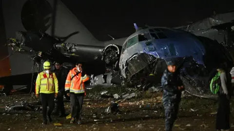 AFP via Getty Images Rescue teams work at the crash site of a Bolivian military plane in El Alto. Photo: 27 February 2026