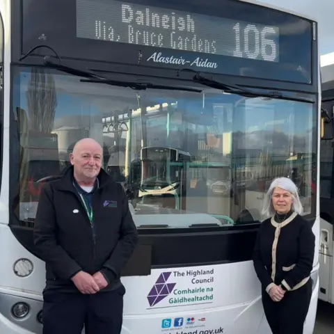 The Highland Council The picture shows the front of a black and while Highland Council bus. It has the route number 106 going to Dalneigh. Two council officials are standing in front of the bus. 