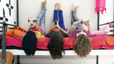 Getty Images Girls reading magazines