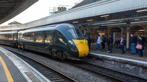 Getty Images A GWR branded train arriving at a platform at Bristol Temple Meads railway station. Passengers are waiting to get on the train.