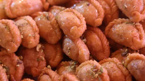 Getty Images Gujiya (Gujhia), a traditional Indian sweet, garnished with coconut flakes, is displayed during the Mithai Mela, an Indian sweets fair, for the upcoming festival of Diwali in Brampton, Ontario, Canada, on October 18, 2025.