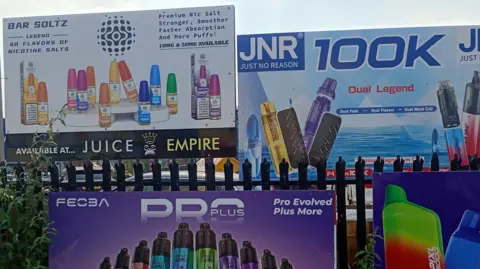 BBC Large adverts for vapes stuck on railings