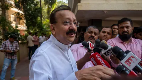 Getty Images Baba Siddique speaks to journalists in February this year