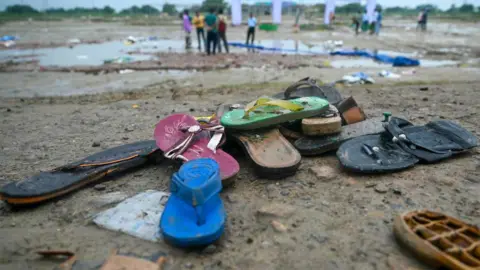Getty Images 2024 年 7 月 3 日，印度北方邦哈特拉斯发生踩踏事件，现场的鞋子被拍到。7 月 3 日，印度十多年来最严重的踩踏事件的幸存者回忆起在一次人满为患的印度教宗教集会上被踩踏的恐怖，那次集会造成 116 人死亡。（图片来源：Arun SANKAR / AFP）（图片来源：ARUN SANKAR/AFP via Getty Images）