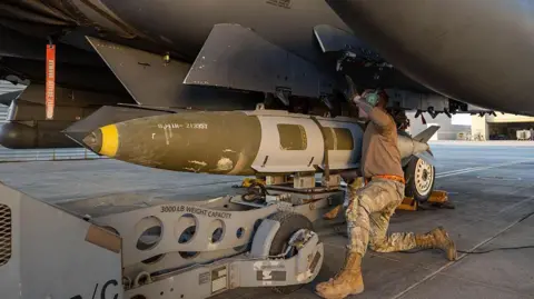 A handout from the US military shows a troop loading a missile for an attack in Syria last month