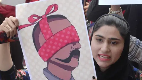 EPA People hold depiction of captured Indian Air Force Pilot Wing Commander Abhinandan, as they shout anti-India slogans during a protest in Lahore, Pakistan, 28 February 2019.