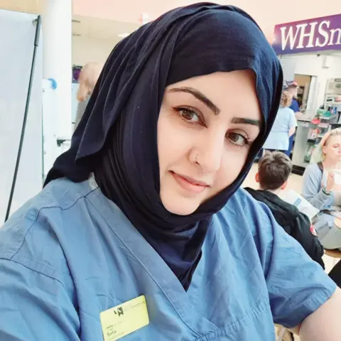 Safia Ahmadei wearing her pupil  caregiver  uniform. 