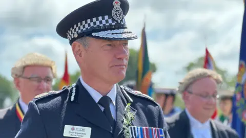 Chief Constable Russ Foster wearing his formal constabulary uniform., including a cap featuring the constabulary emblem.