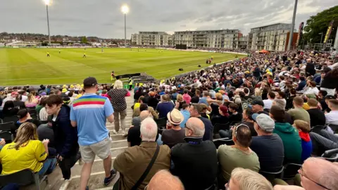 Steve Mellen/BBC The crowd watch Gloucestershire play Somerset under floodlights in the Vitality Blast at the county ground in Bristol