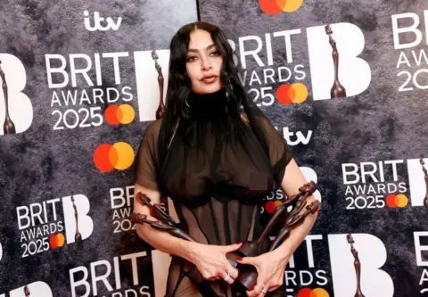 Getty Images Charli XCX berpose dengan penghargaan Brit -nya